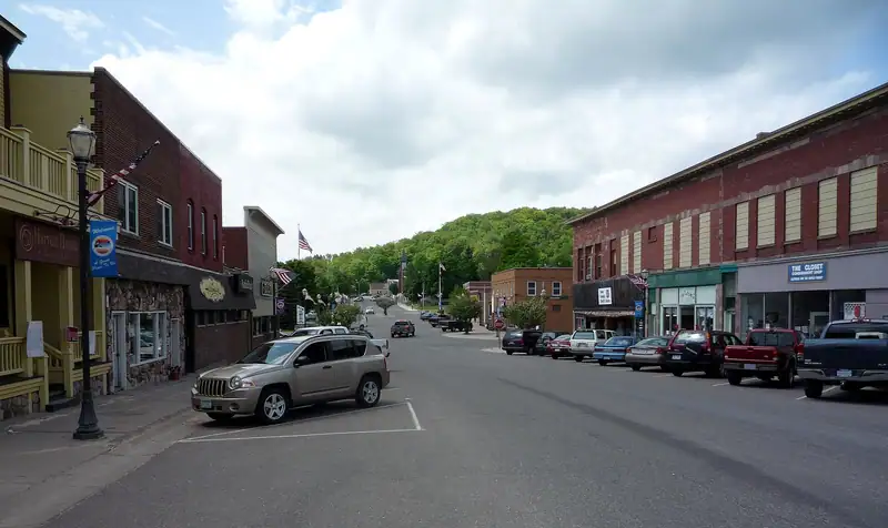 Storefronts on Elm Avenue with wooded hills beyond