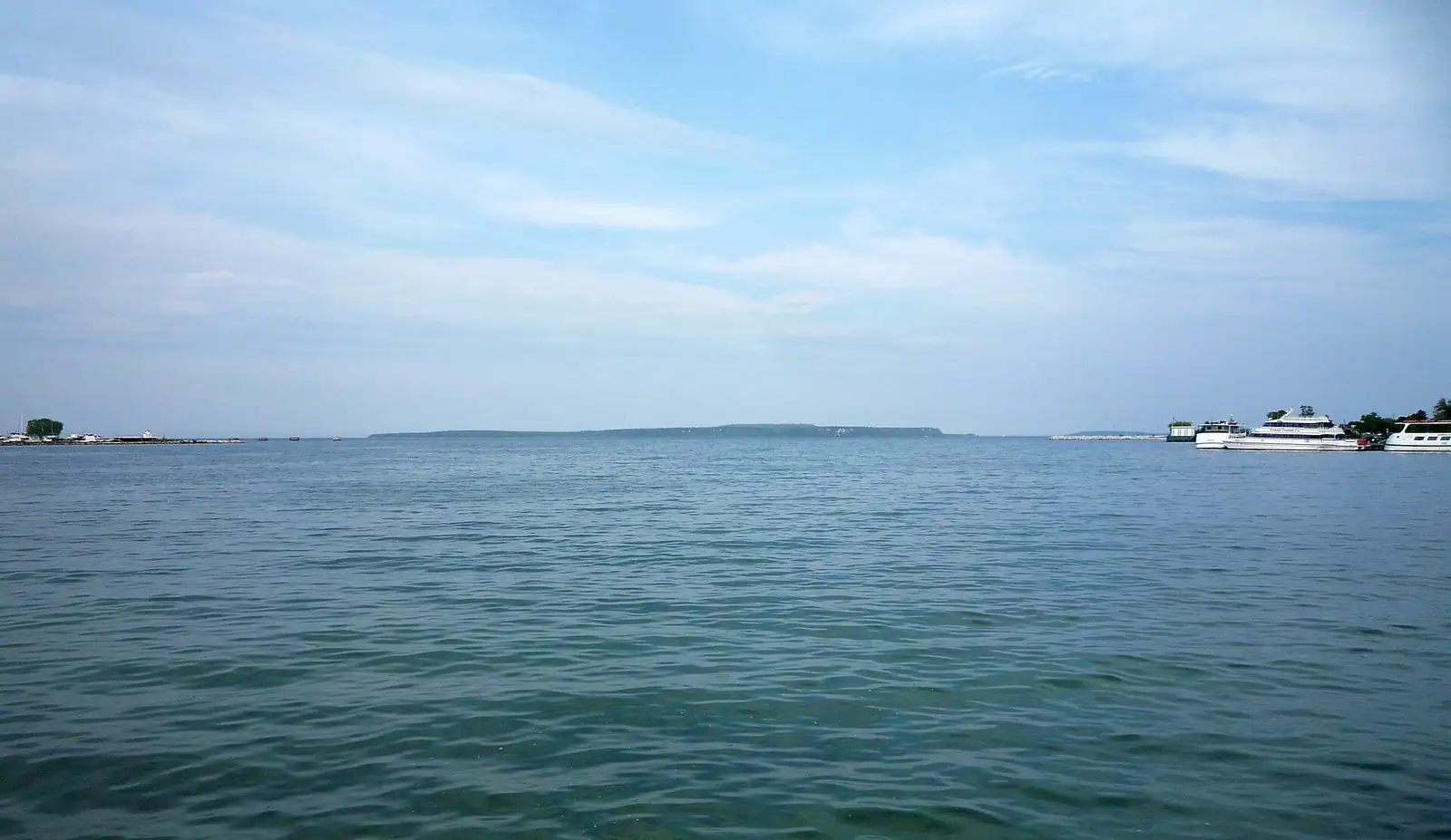 A calm harbor with an island on the horizon