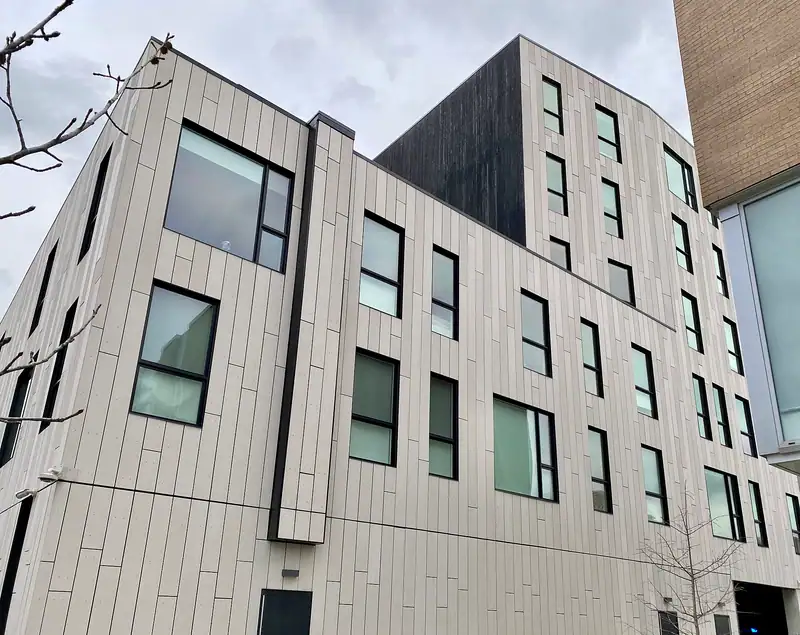 A modern multi-unit building with light cladding