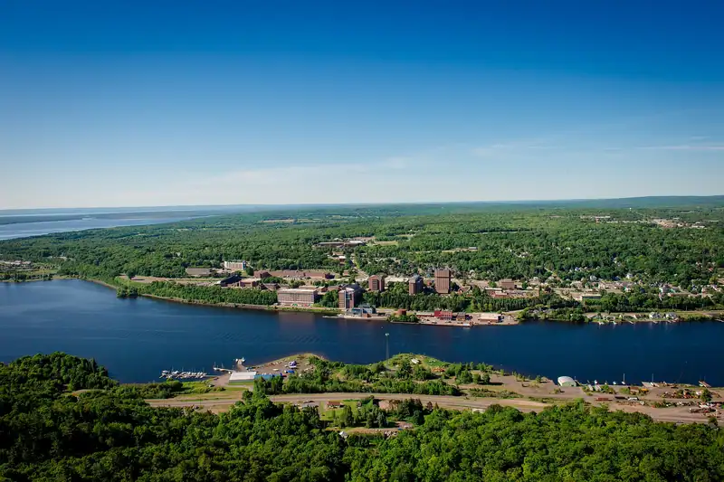 Aerial view of a hillside campus beside the water