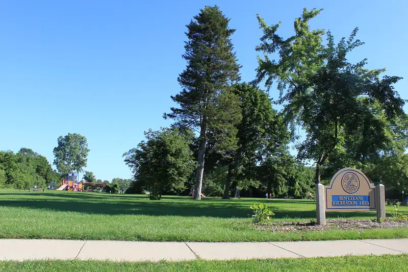 A park entrance with lawns and tall evergreens