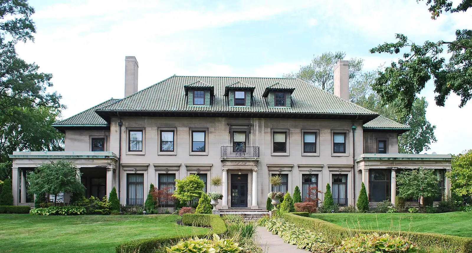 A large historic home with a broad front lawn