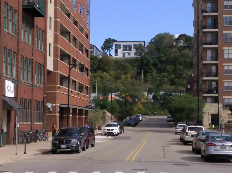A street climbing a hill lined with homes and newer buildings