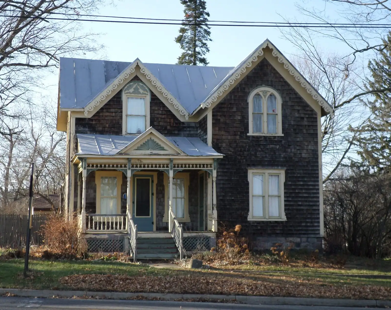 A Victorian house with a steep roof and porch