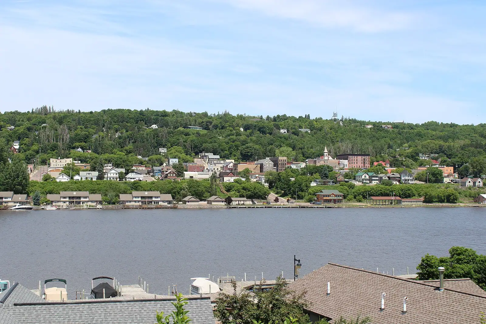 A hillside town above the waterway under a blue sky
