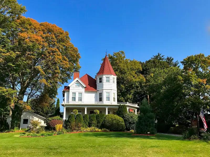 A Victorian house with a turret and wraparound porch