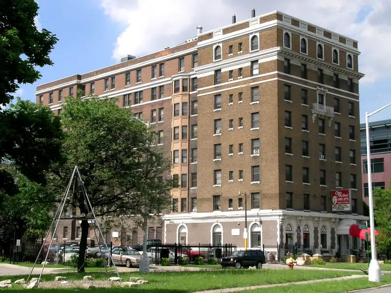 A multi-story historic brick apartment building on a corner
