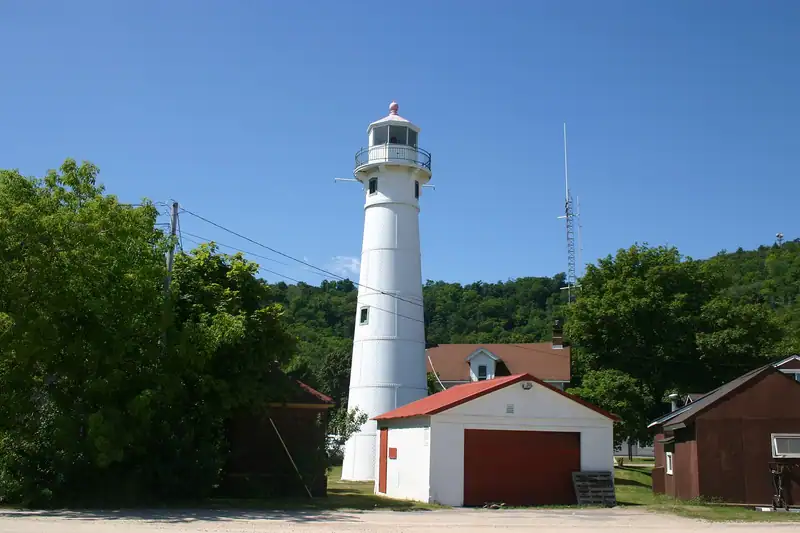A white lighthouse tower among trees