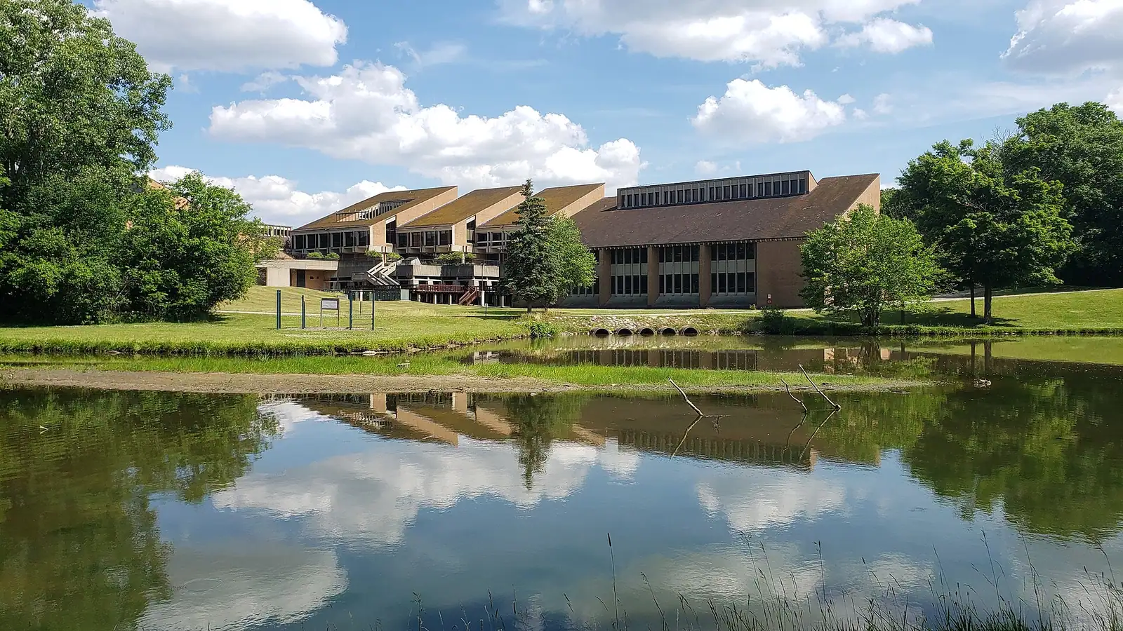 Buildings reflected in a pond on a sunny day