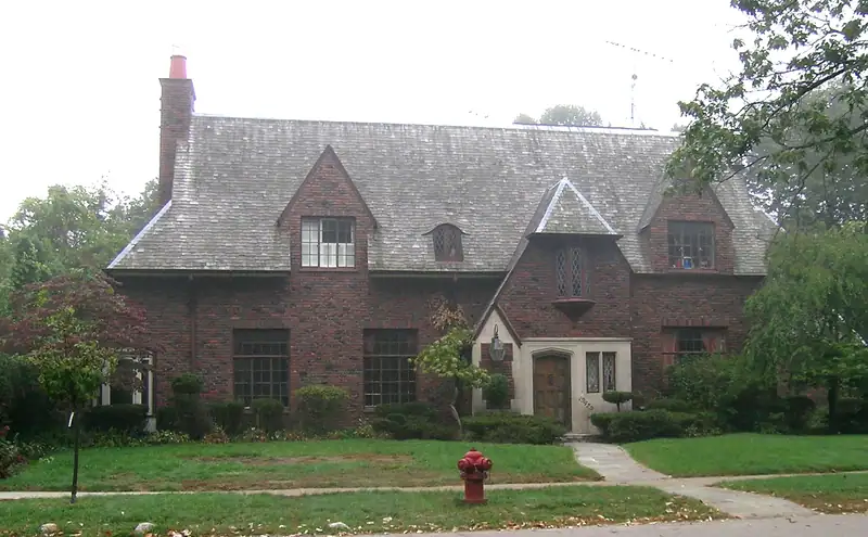 A brick home set among tall trees