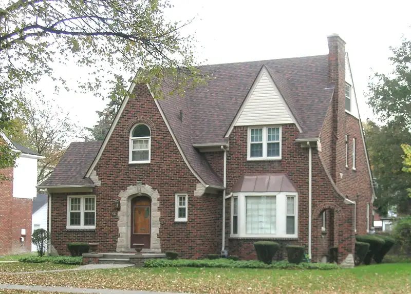 A brick home with a steep gabled roof
