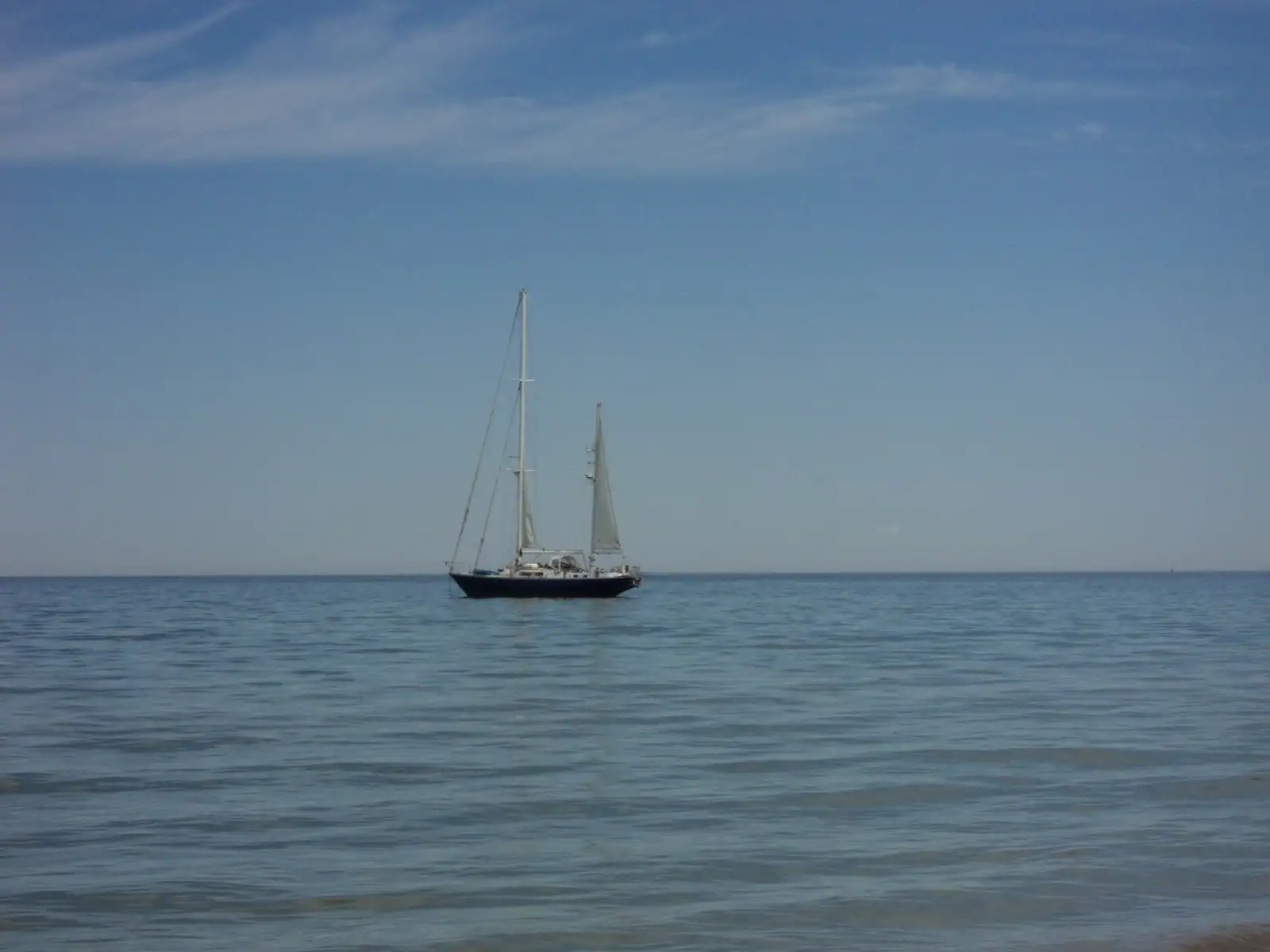 A sailboat on calm blue Lake Michigan water