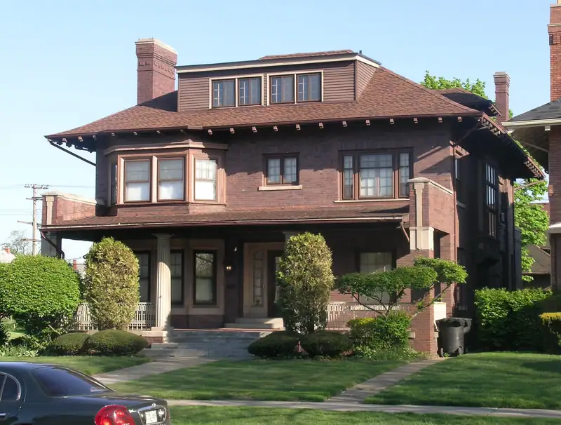 A historic brick home with a broad porch